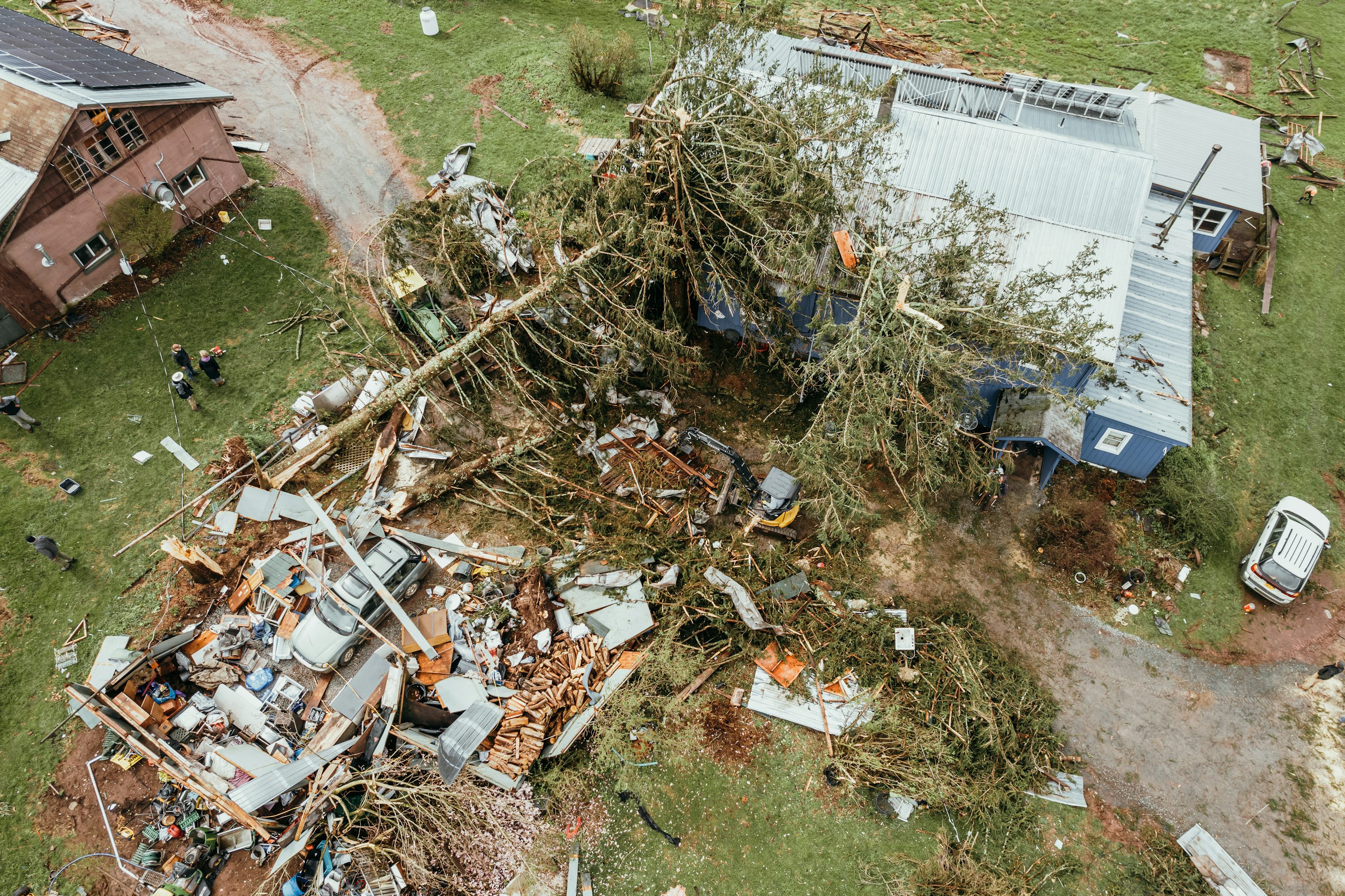Aerial drone view of tornado damage — tree on house, debris in Mitchell County